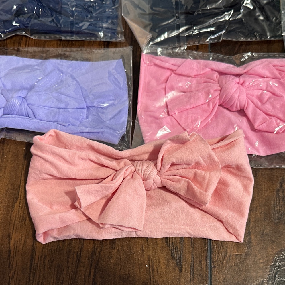 14 Nylon baby bow headbands. New, one opened for picture.